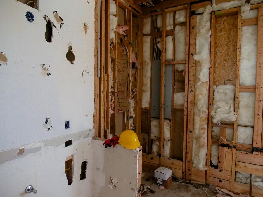 A rectangular access opening cut into drywall, exposing the stud cavity behind
