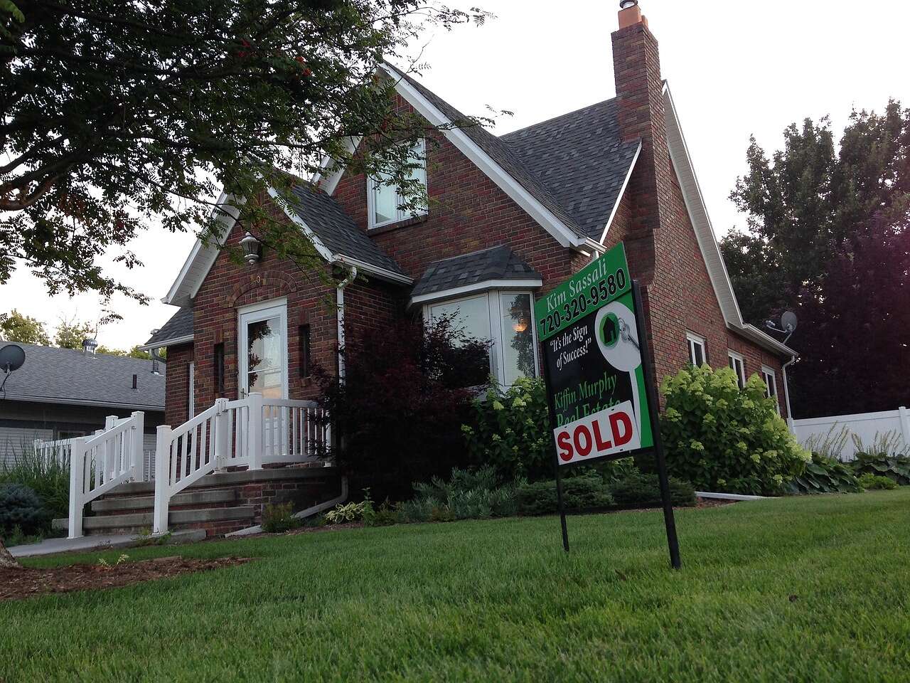 A Tudor Revival house with a sold sign in the front yard