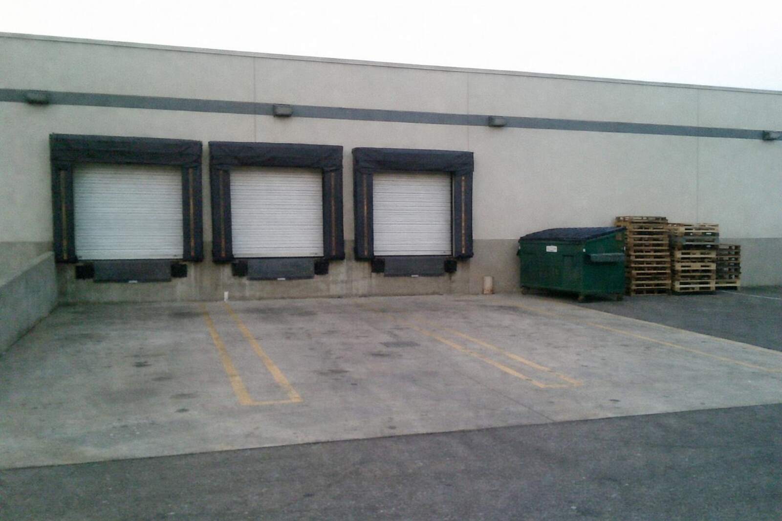 A loading dock with roll-up doors at a light industrial building